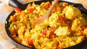 Pui cu orez în stil columbian. Rețetă cu legume, cârnați afumați și turmeric
